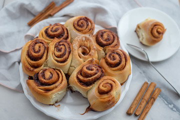 Cinnamon rolls with sugar frosting. With cinnamon sticks and spices, wooden background