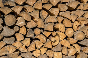 Pile of woods in front of a house. Logs, Fuel for heating. Wooden firewood stacked. Natural wood background