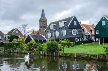 Fototapeta na wymiar Traditional wooden fishing houses, canal and swan, Marken, Netherlands
