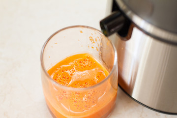 detox. smoothies. the process of making juice in the kitchen. A glass of fresh carrot juice. carrot and Apple on the table. detoxification, vegetarian diet. juicy healthy vitamin drink. juicer.