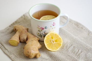 Closeup shot of ginger and ginger tea with lemon in the decorative container