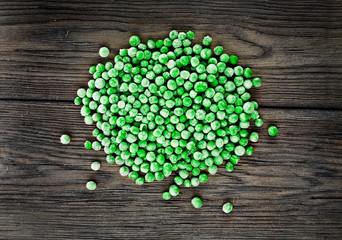 Heap of frozen pea on a old wooden table. Top view.
