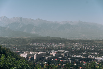 Kazakhstan. View of the city of Almaty. Summer, sunny weather. Tall buildings on a background of mountains
