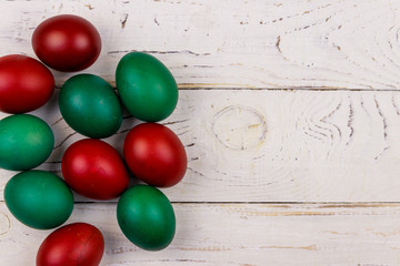 Painted Easter eggs on white wooden background
