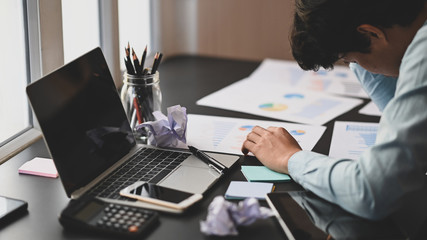Photo of young businessman hand on his head at the working desk after feeling frustrated exhausted...