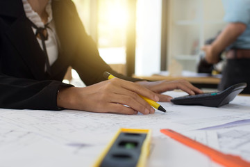 Female engineer calculates the price of a high-rise building project to the executive for future investment approval.