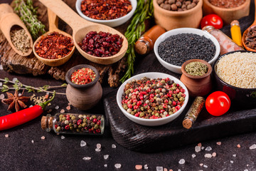 Spices and herbs over black stone background. Top view with free space for menu or recipes