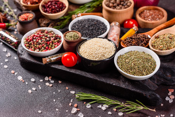 Spices and herbs over black stone background. Top view with free space for menu or recipes