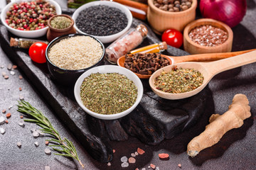 Spices and herbs over black stone background. Top view with free space for menu or recipes