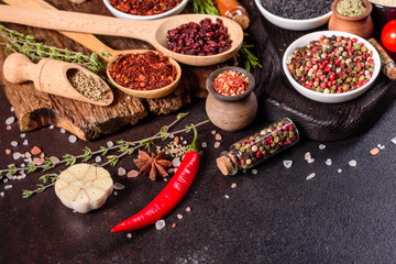 Spices and herbs over black stone background. Top view with free space for menu or recipes