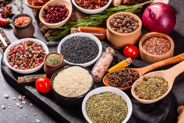 Spices and herbs over black stone background. Top view with free space for menu or recipes
