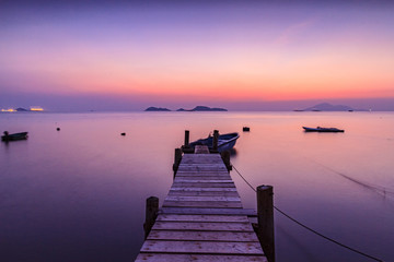 Magic hour after sunset in a fishing village in Hong Kong, with a small wooden bridge in the middle