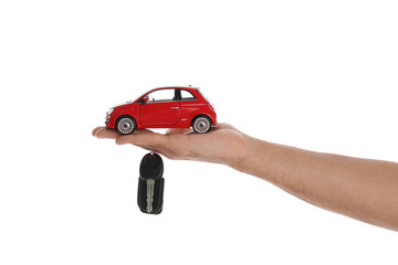 Man holding key and miniature automobile model on white background, closeup. Car buying