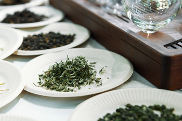 Paper plates with black, green and red tea.