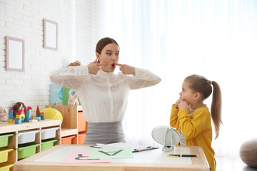 Fototapeta premium Speech therapist working with little girl in office