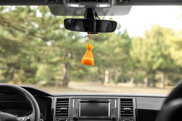 Air freshener hanging on rear view mirror in car
