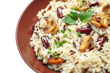 Delicious rice pilaf with mushrooms and beans isolated on white, closeup