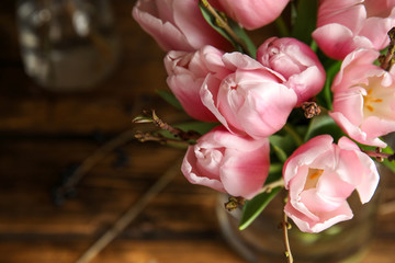 Beautiful bouquet with spring pink tulips on table, above view