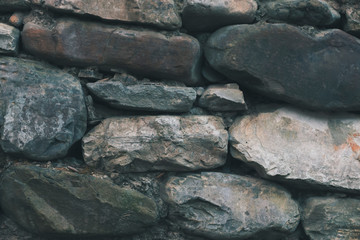 Close up old abandoned cobblestone wall. Part of the stone wall of the defensive structures of the Second World War. Abstract texture background.