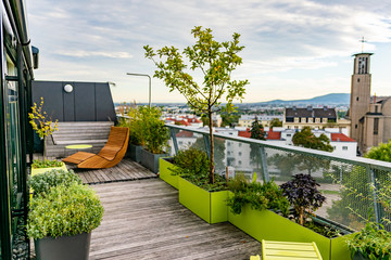 Rocking lounger on a roof terrace with bamboo and grasses and outdoor furniture.