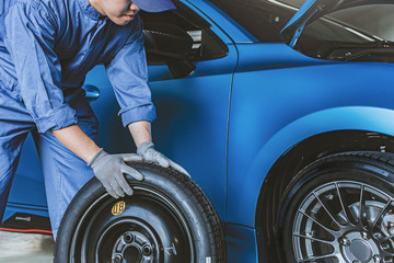 Asian man car inspection Measure quantity Inflated Rubber tires car.Closeup hand holding tire and blue car for tyre pressure measurement for automotive, automobile Car industry image