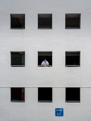 asian man looking outside a window in a carpark