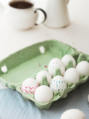 Holidays, tradition and people concept - close up of woman hands coloring easter eggs with brush