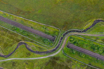 Drone shot of a footpath that takes you towards Whernside which passes over a railway line and stream