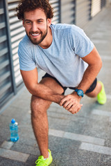 Young man exercising / stretching in urban area.