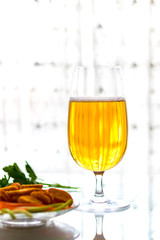 Fresh beer in a glass on the table, with crackers. Vertical orientation