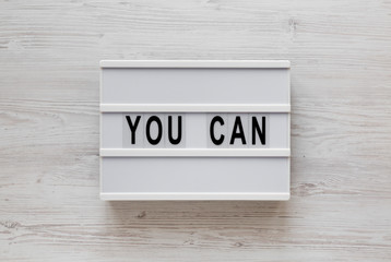 'You can' words on a modern board on a white wooden background, top view. Overhead, from above, flat lay. Close-up.
