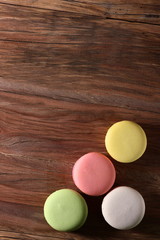 colored French cakes on a textured wooden background