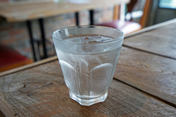 Close up glass of iced spring water on wooden table