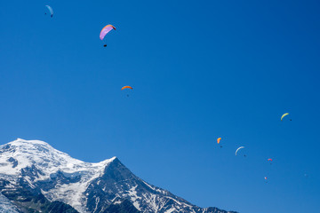 Paragliders looking for thermals amongst the snow caps of the Monte Blanc Massif, Chamonix, France