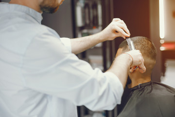 A man in a barbershop. A man cuts hair in a barber. Rest in hairdressing salon
