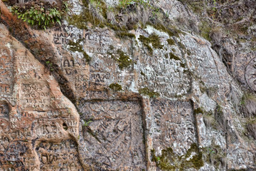 Natural cave in sandstone rock, former bank of Gauja river. Carved wall in Gutmanis cave in...