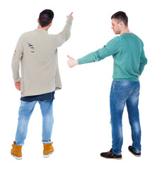 Back view of couple couple in sweater pointing.