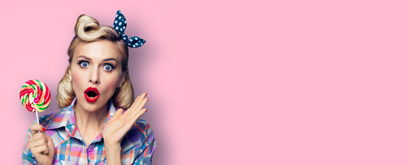 Retro fashion and vintage concept - excited surprised woman with lollipop. Girl pin up with open...