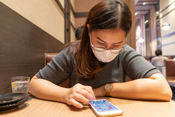 January 28, 2020 Bangkok. Young women at the restuarant wearing surgical mask to prevent flu disease, this due to an outbreak of Corona Virus or Wuhan Virus in Asia.