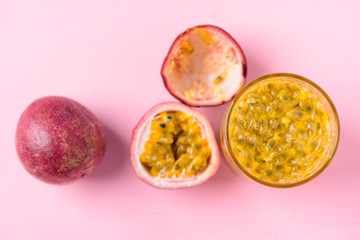 Fresh passion fruit and juice on pink background, top view