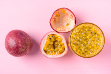 Fresh passion fruit and juice on pink background, top view