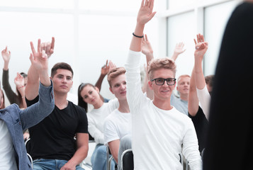 group of young people raising their hands to ask a question.