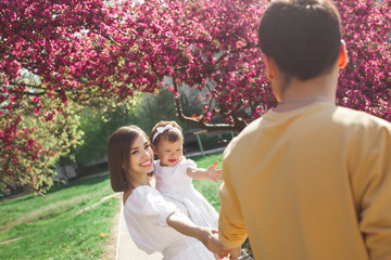 Happy family walking in park. Smiling mother and child with dad outdoors.