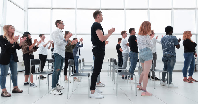 group of young people standing applauding in the conference room.