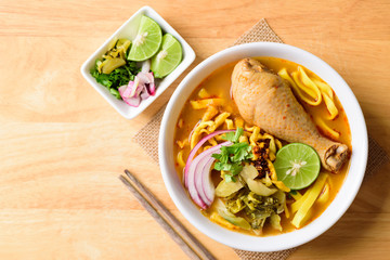 Northern Thai food (Khao Soi Kai), spicy egg noodles soup with chicken and mix of deep-fried egg noodles, pickled mustard greens, shallots, lime and coriander leaves