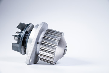 New metal automobile pump for cooling the engine of a water pump on a gray background. The concept of new spare parts for the car engine