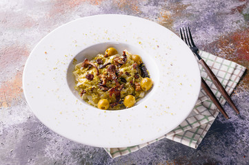 Fettuccini pasta with chanterelle mushrooms, olives and pesto in a white plate. Italian Mediterranean cuisine. Close up