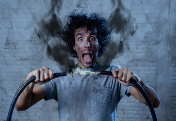 Funny image of man getting electric shock with funny face and smoke all around. DIY concept