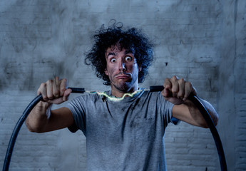Funny image of man getting electric shock with funny face and smoke all around. DIY concept