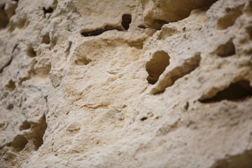 Texture light sand rock, overhanging layers. Sand-colored limestone, natural wall